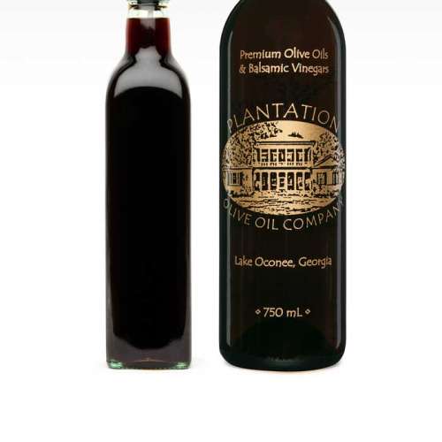 Photo showing dark balsamic vinegar in dispenser bottle to the left of large bottle of A-Premium Dark Balsamic.