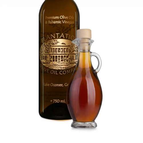 Photo showing small glass dispenser bottle of white balsamic vinegar next to large bottle of white balsamic vinegar.