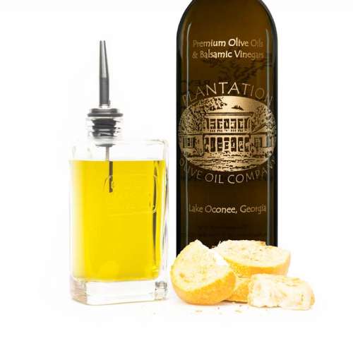 Arbequina extra virgin olive oil bottle next to toasted wedges of bread.