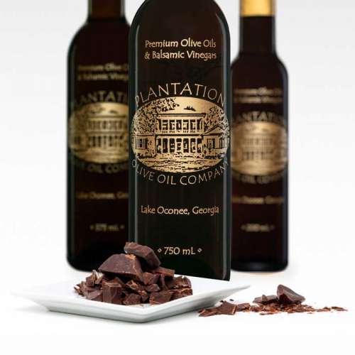 Photo showing small dish of dark chocolate chunks in front of three bottles of dark balsamic vinegar