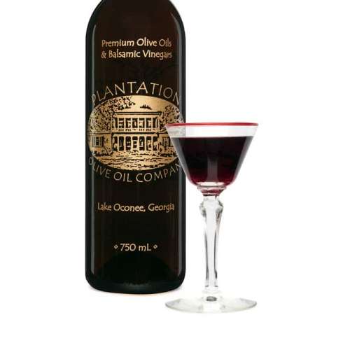 Photo showing glass of sherry in front of large Plantation balsamic vinegar bottle.