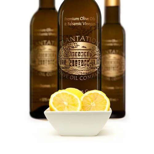Photo showing small dish overflowing with Sicilian lemons in front of three bottles of white balsamic vinegar.