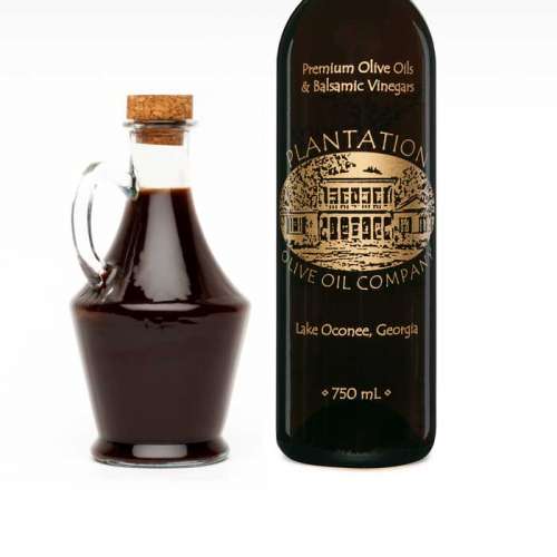 Photo showing cruet bottle filled with dark balsamic vinegar to the left of large Plantation vinegar bottle.