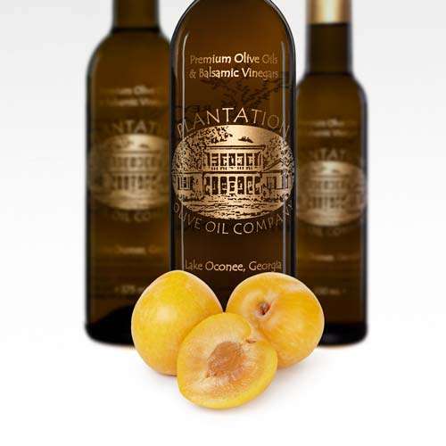 Fresh umeboshi plums lay in front of three bottles of gourmet white balsamic vinegar.